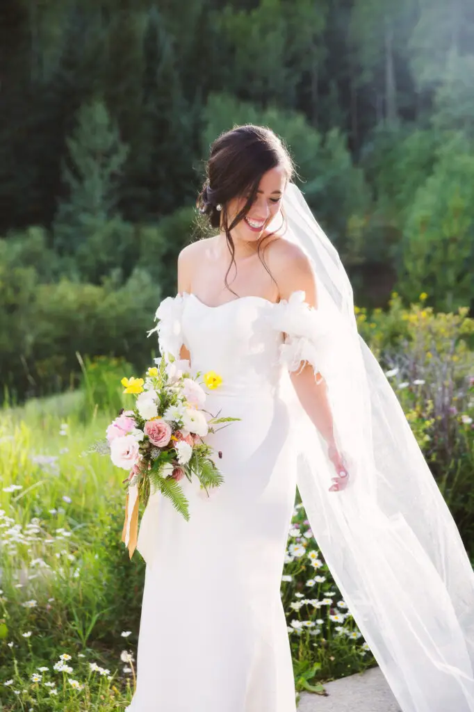 aspen bride standing in light holding bouquet