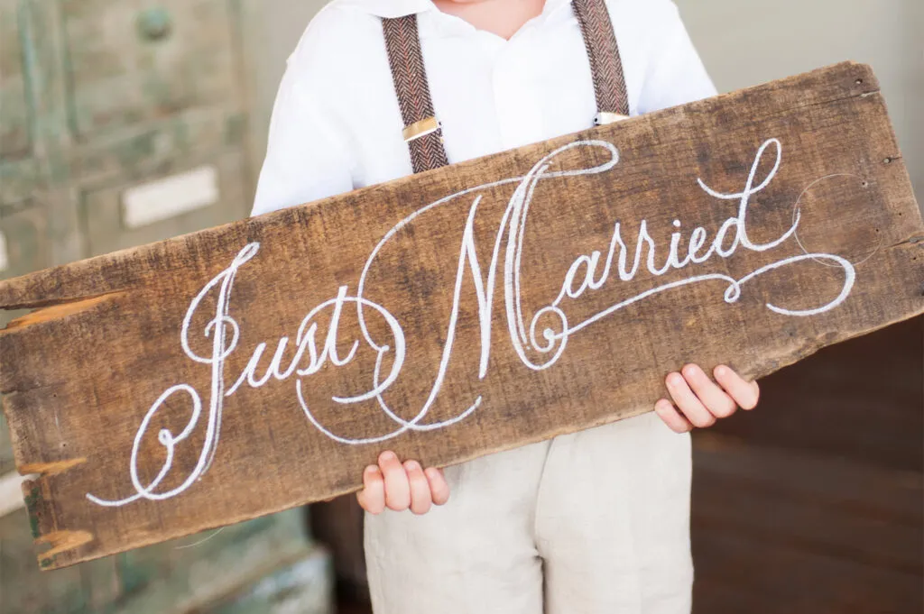kid holding just married sign