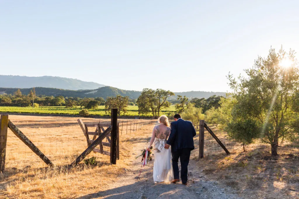 bride and groom walking into sunset